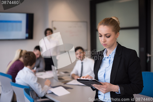 Image of business woman working on tablet at meeting room