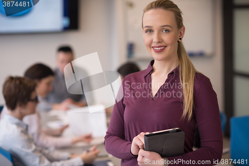 Image of blonde businesswoman working on tablet at office