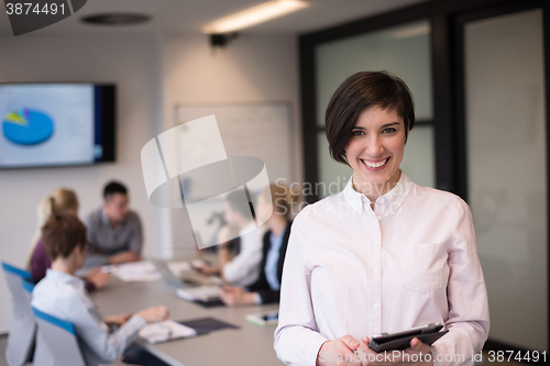 Image of hispanic businesswoman with tablet at meeting room