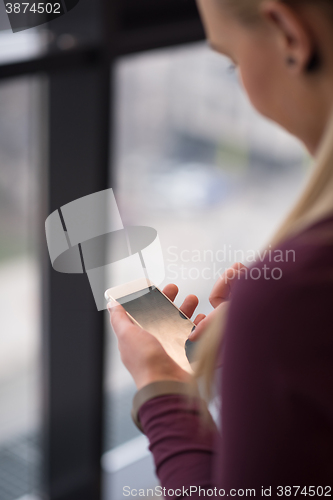 Image of business woman using smart phone at office