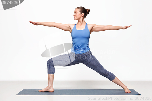 Image of Woman practices yoga asana utthita Virabhadras