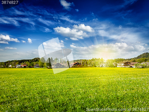 Image of Countryside meadow field with sun and blue sky