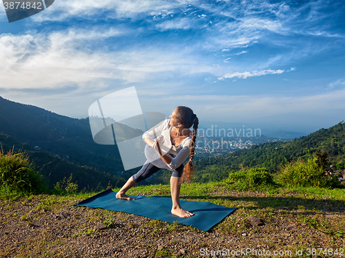 Image of Woman practices yoga asana Utthita Parsvakonasana