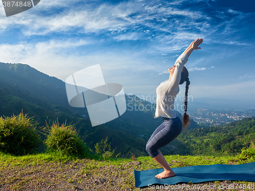 Image of Woman doing yoga asana Utkatasana outdoors