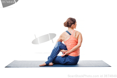 Image of Woman practices yoga asana  Ardha matsyendrasana