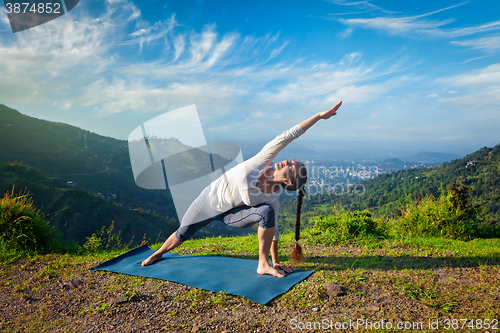 Image of Woman practices yoga asana outdoors