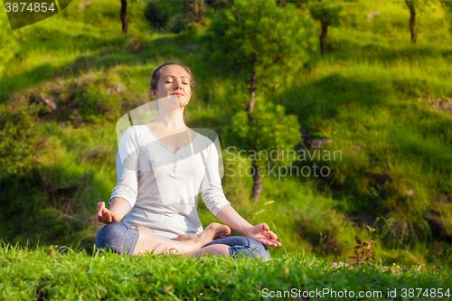 Image of Young sporty fit woman in yoga Lotus pose oudoors 