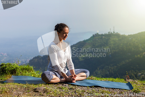 Image of Woman practice yoga asana Baddha Konasana outdoors