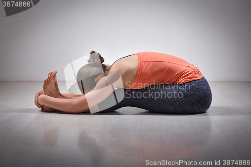 Image of Woman practices Ashtanga Vinyasa yoga asana