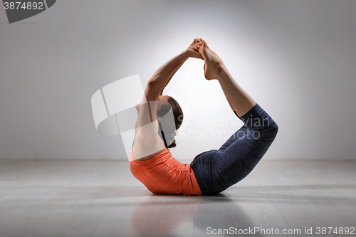 Image of Sporty fit woman practices yoga asana Dhanurasana