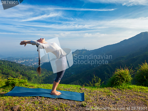 Image of Woman doing yoga Sun Salutation Surya Namaskar