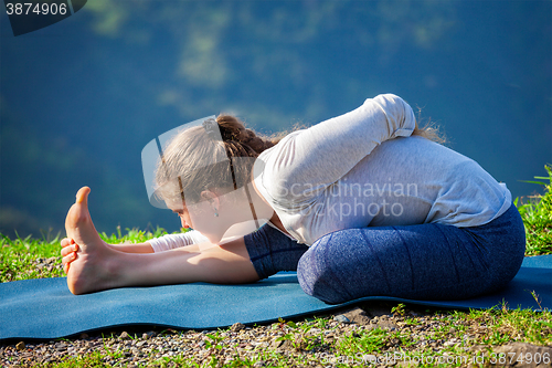 Image of Woman doing yoga asana outdoors