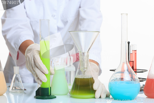 Image of hands holding test tubes with chemical elements. 