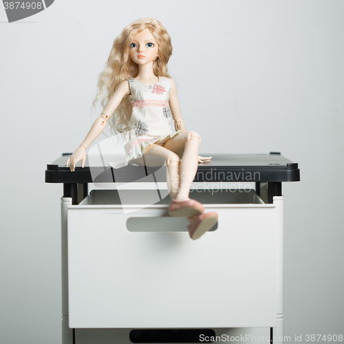 Image of doll in a box on a light background. blurred rear plan