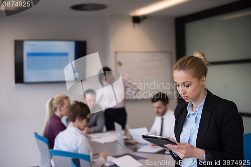 Image of business woman working on tablet at meeting room