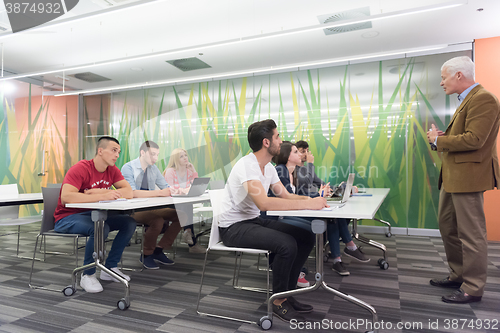Image of teacher with a group of students in classroom