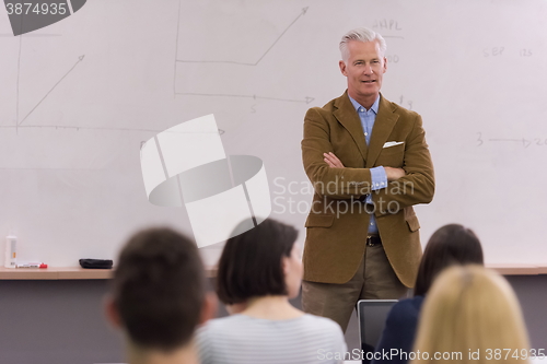 Image of teacher with a group of hi school students in classroom