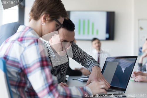 Image of young business couple working on laptop, businesspeople group on