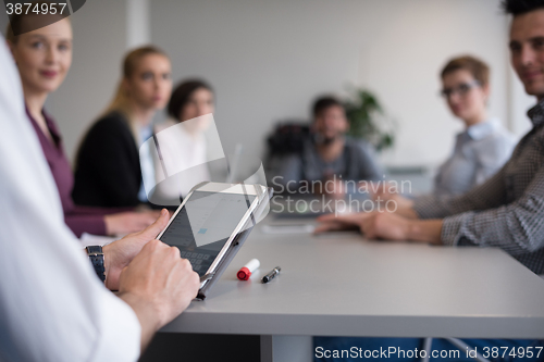 Image of close up of  businessman hands  using tablet on meeting