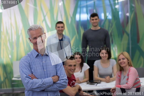 Image of portrait of  teacher with students group in background