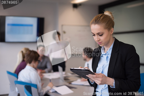 Image of business woman working on tablet at meeting room