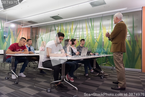 Image of teacher with a group of students in classroom