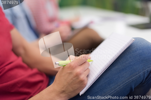 Image of male student taking notes in classroom