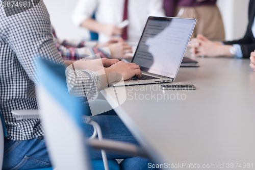 Image of close up of business man hands typing on laptop with team on mee