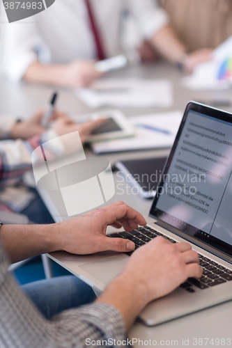 Image of close up of business man hands typing on laptop with team on mee