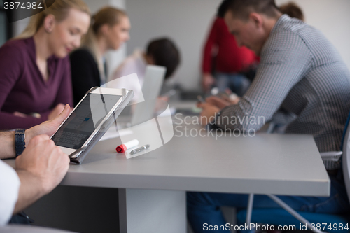 Image of close up of  businessman hands  using tablet on meeting