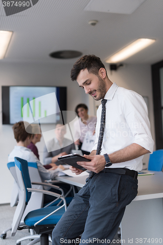 Image of young business man with tablet at office meeting room