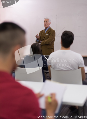 Image of male student taking notes in classroom