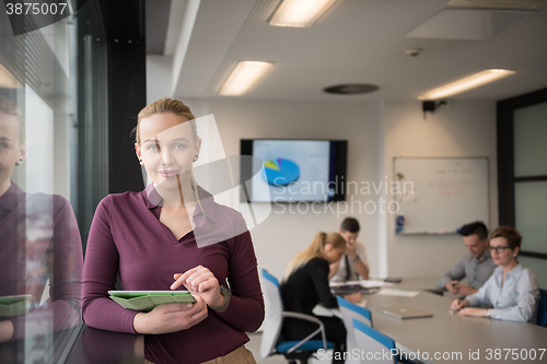 Image of blonde businesswoman working on tablet at office
