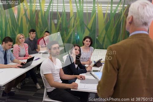 Image of teacher with a group of students in classroom