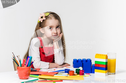 Image of Cute little girl drawing with paint and paintbrush at home