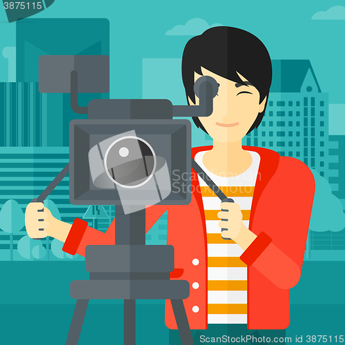 Image of Cameraman with movie camera on a tripod.