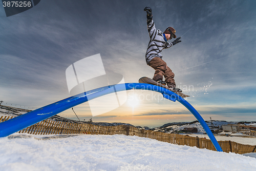 Image of Snowboarder sliding on a rail