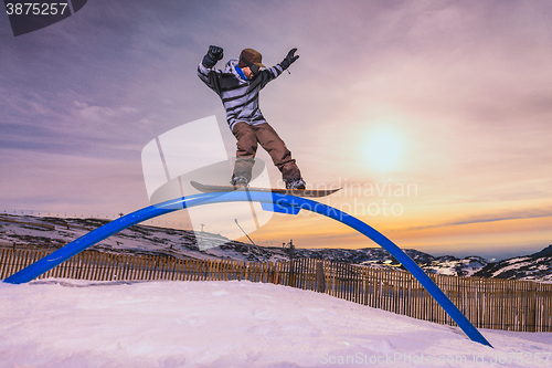 Image of Snowboarder sliding on a rail