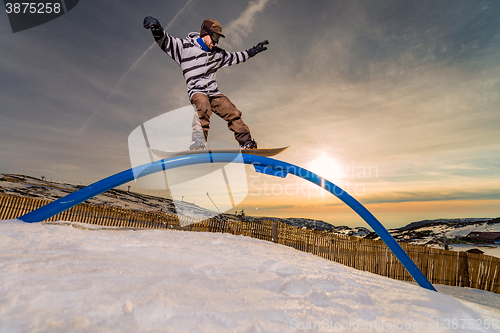 Image of Snowboarder sliding on a rail