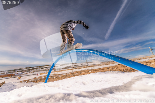 Image of Snowboarder sliding on a rail