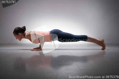 Image of Woman practices yoga asana Chaturanga Dandasana