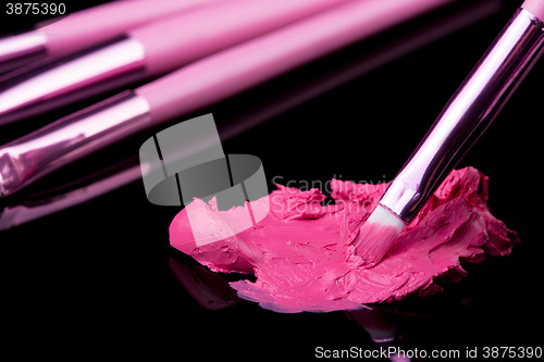 Image of lipstick with a brush make-up on black 