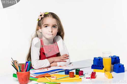Image of Cute little girl drawing with paint and paintbrush at home