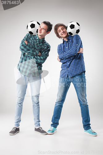 Image of The two boys with balls on gray background