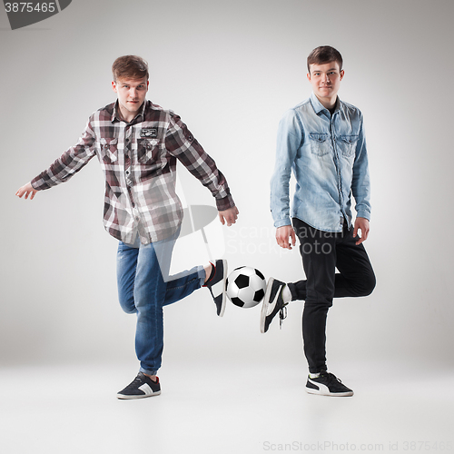 Image of The two boys with balls on gray background