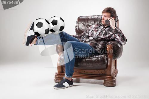 Image of The portrait of fan with balls, holding phone on gray background