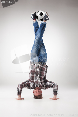 Image of Portrait  of young man, practicing yoga with football balls