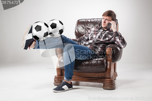 Image of The portrait of fan with balls, holding phone on gray background