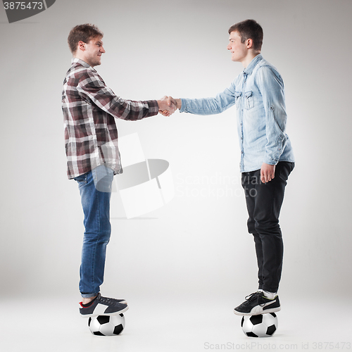 Image of The two boys with balls on gray background