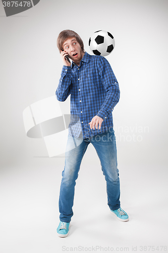 Image of The portrait of fan with ball, holding phone on white background